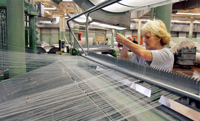 Tallassee Mills employee Kathy   Redden rethreads a warper machine on the floor of the cloth factory in Tallassee, Alabama. (AP/Rob Carr)