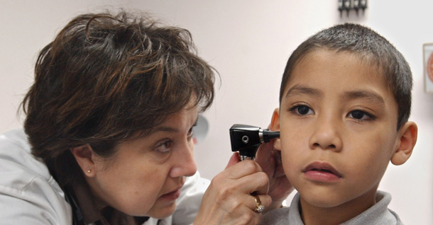 Chris Taylor, a doctor, left, examines the ear of Richard Alvarez at the Las Palmas Health Clinic in Sacramento, CA. Lack of affordable health insurance undermines the health and economic security of many Americans. (AP/Rich Pedroncelli)