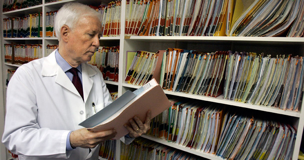 Dr. Cecil Wilson looks at a paper chart for one of his patients in Winter Park, Florida. (AP/John Raoux)