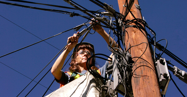 A technician does repair work on a telephone pole for Qwest Communications International, which has a number of major contracts with the federal government. (AP/Jack Dempsey)