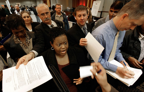 Job seekers hand over resumes while trying to get information at a job fair in Livonia, MI. More than 1 million people will run out of unemployment  benefits in January 2010 unless Congress quickly extends federal emergency aid. (AP/Paul Sancya)