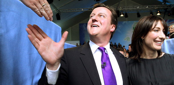 Conservative party leader David Cameron reaches out to shake hands with a supporter as he leaves the Battersea Power Station with his wife Samantha. (AP/Oli Scarf)