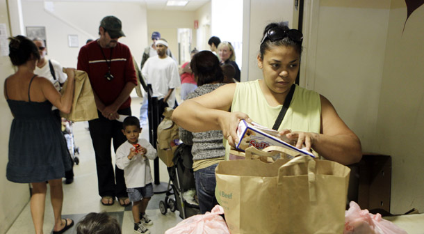 A woman stocks up on food at Sacred Heart Community Center's pantry in San Jose, CA, on September 16, 2010. California is set to hold a statewide symposium to engage stakeholders in tackling poverty in the state. (AP/Marcio Jose Sanchez)