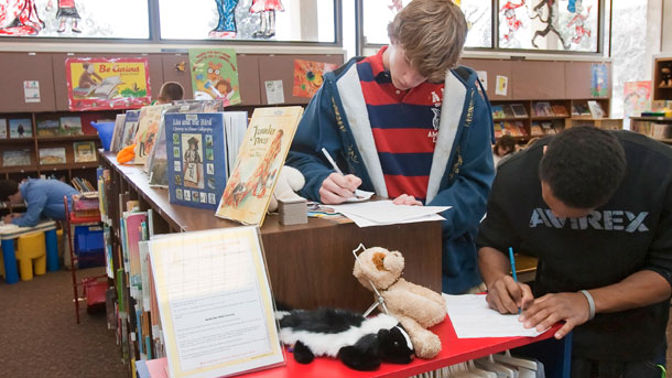 Teenagers fill out summer job applications at a library. (AP/Nati Harnik)