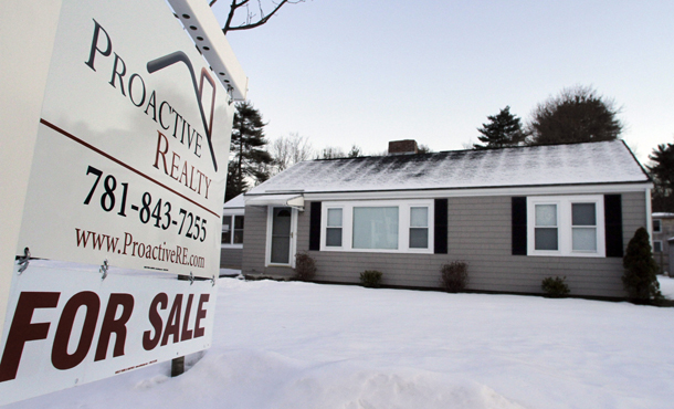 In this file photo taken January 10, 2011, a "for sale" sign hangs in front of a home in Millis, Massachusetts. (AP/Steven Senne)
