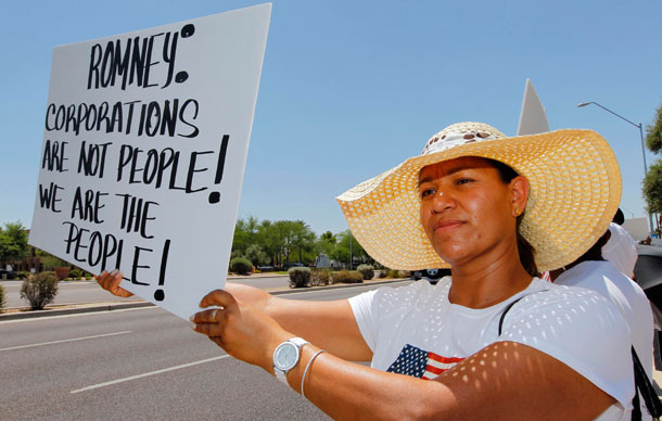 Martha Espinosa stands outside a Scottsdale, Arizona, resort to protest against Republican presidential candidate and former Massachusetts Gov. Mitt Romney, who was speaking inside, and Arizona's controversial immigration law, S.B. 1070.
