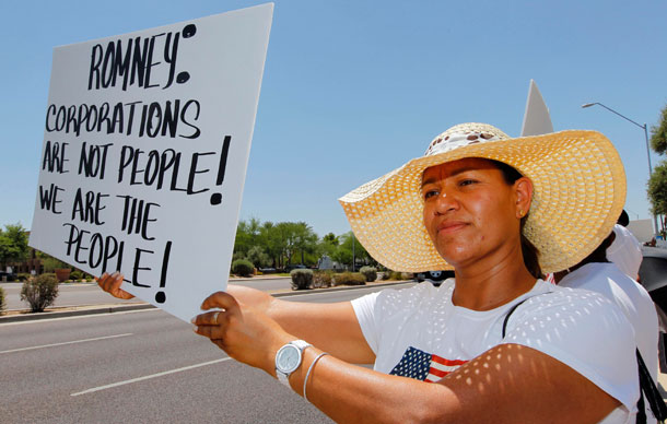 Martha Espinosa stands outside a Scottsdale, Arizona, resort to protest against Republican presidential candidate and former Massachusetts Gov. Mitt Romney, who was speaking inside, and Arizona's controversial immigration law, S.B. 1070.