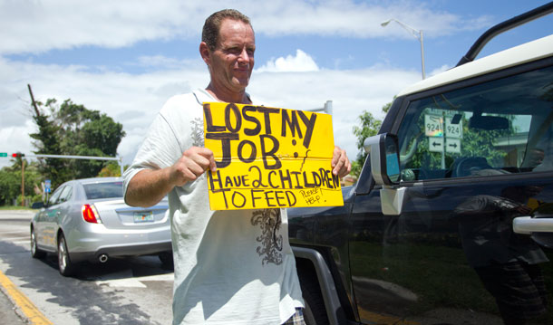 An unidentified man, who lost his job two months ago after being hurt on  the job, works a Miami street corner to collect money for his family on September 16, 2010. The man said his unemployment check did not  cover costs of living. (AP/J Pat Carter)