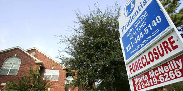 A foreclosure sign is see in front of a house in Spring, Texas. (foreclosure sign in front of house)