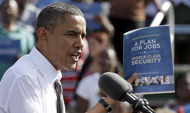 President Barack Obama holds up a copy of his plan for jobs as he speaks to supporters during a campaign stop in Delray Beach, Florida, Tuesday, October 23, 2012. (AP/Alan Diaz)