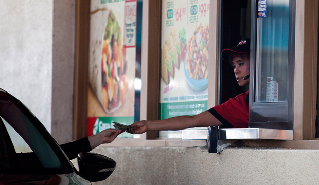 A Carl's Jr. employee gives a customer their change through a drive-through window in San Diego on Friday, September 13, 2013. (AP/Sam Hodgson)