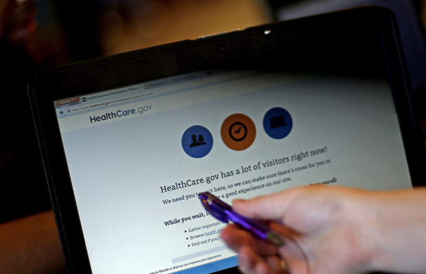 Elizabeth Rich points to a web page for the Affordable Care Act as she helps people sign up for health insurance at Swope Health Services in Kansas City, Missouri, March 31, 2014. (AP/Charlie Riedel)