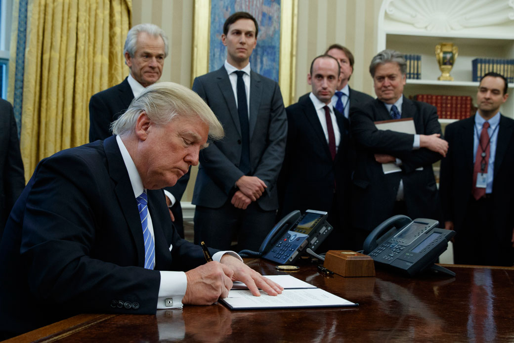President Donald Trump signs an executive order implementing a federal government hiring freeze on January 23, 2017, in the Oval Office. (AP/Evan Vucci)