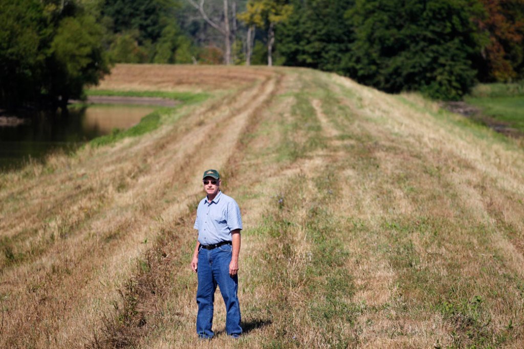 A farmer poses atop a levee protecting his land from Mississippi River flooding on August 11, 2011. (AP/Jeff Roberson)