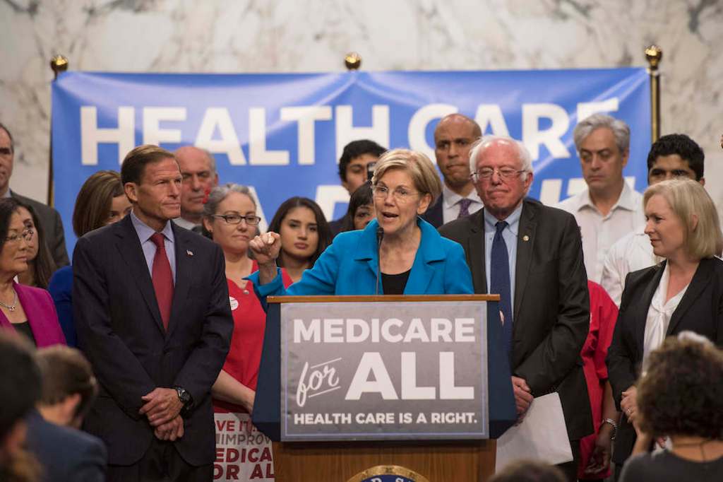 Sen. Elizabeth Warren (D-MA) speaks with Sen. Bernie Sanders (I-VT) about Medicare for All legislation on Capitol Hill in Washington, D.C., September 2017. (Getty/Jim Watson/AFP)