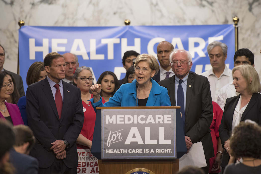 Sen. Elizabeth Warren (D-MA) speaks with Sen. Bernie Sanders (I-VT) about Medicare for All legislation on Capitol Hill in Washington, D.C., September 2017. (Getty/Jim Watson/AFP)