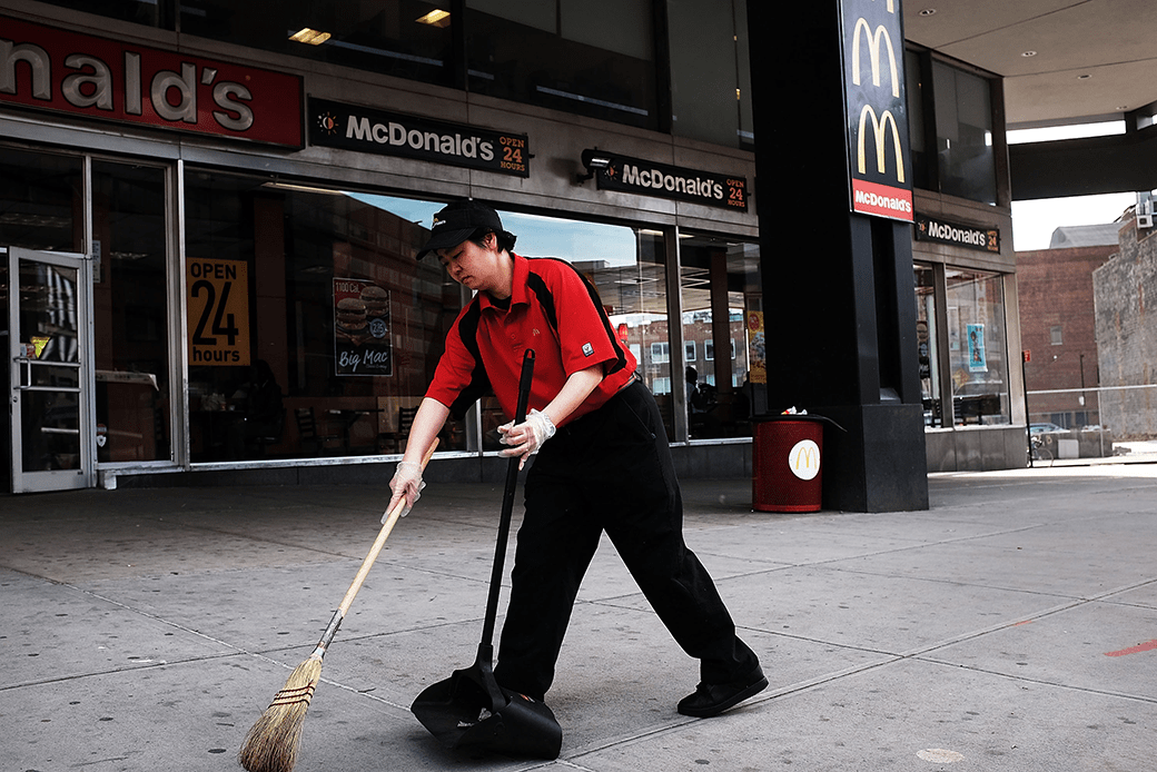 (A McDonald's employee is shown sweeping the sidewalk in front of a store in Brooklyn, New York.)