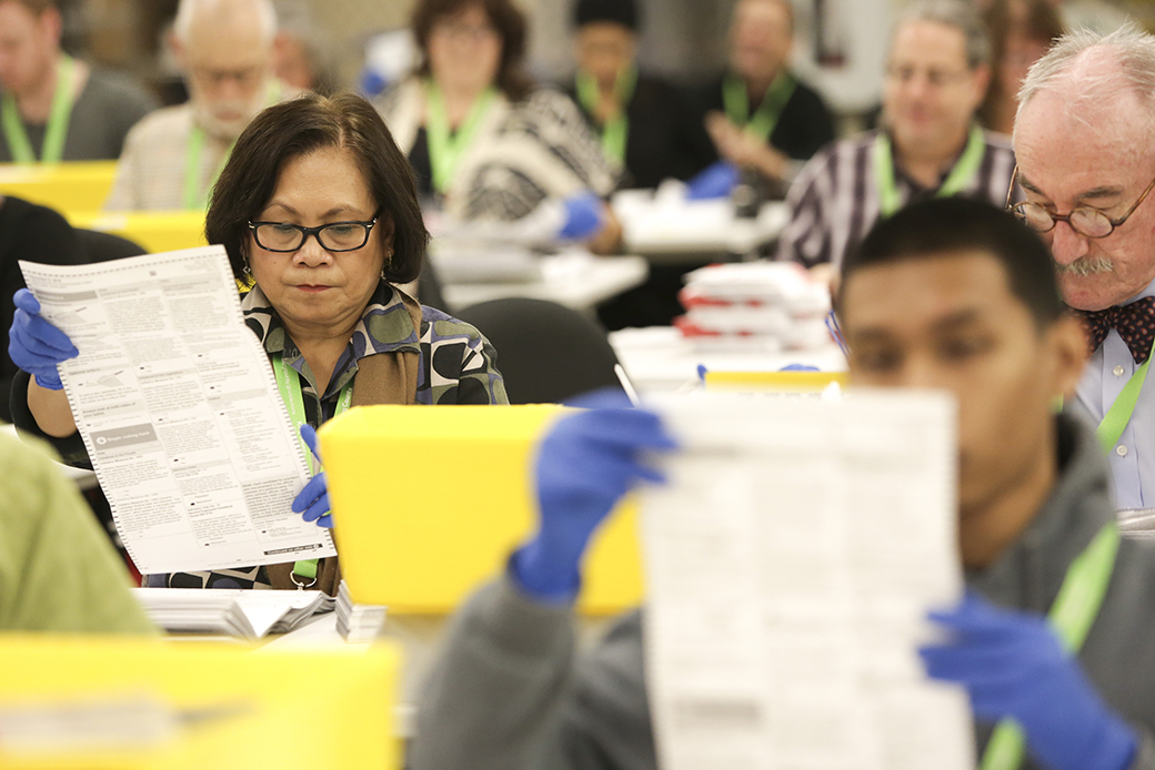 Temporary election staff open and inspect mail-in ballots before scanning them in Washington state on November 2, 2016. (Getty/Jason Redmond)