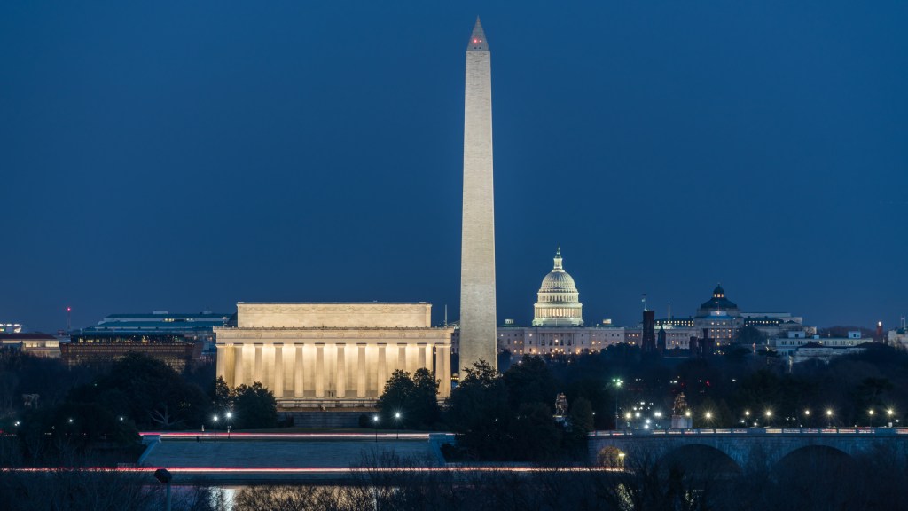 This twilight view from Arlington, Virginia looks east across the Potomac River toward the monuments on the National Mall in Washington, DC. Seen here are the Lincoln Memorial, Washington Monument, US Capitol Building and the Library of Congress.