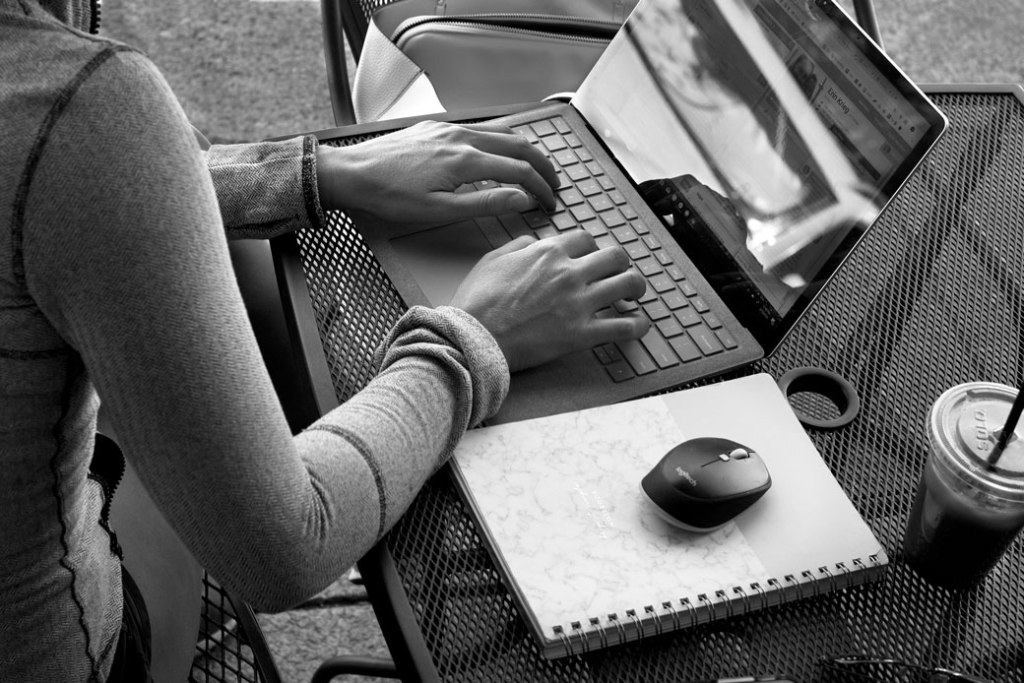 A woman uses her laptop computer at an outdoor cafe in Jacksonville, Oregon, June 2019. (Getty/Robert Alexander)