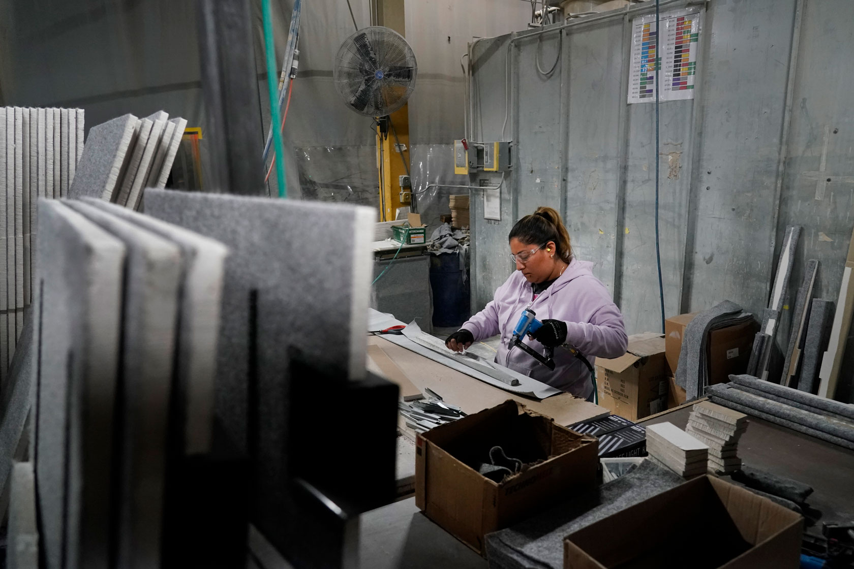 A worker assembles the interior of a safe that is being manufactured at a factory.