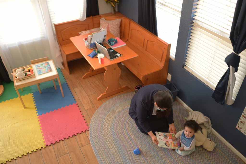 An educator reads to a 6-month-old girl at a child care center in Denver.