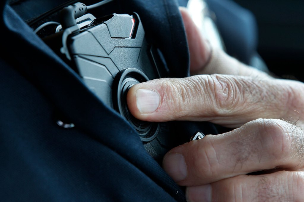 Photo shows a close-up of an officer pressing a button on his uniform.