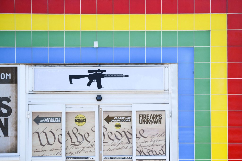 An AR-15-style rifle is displayed on signage for an Arizona gun store.