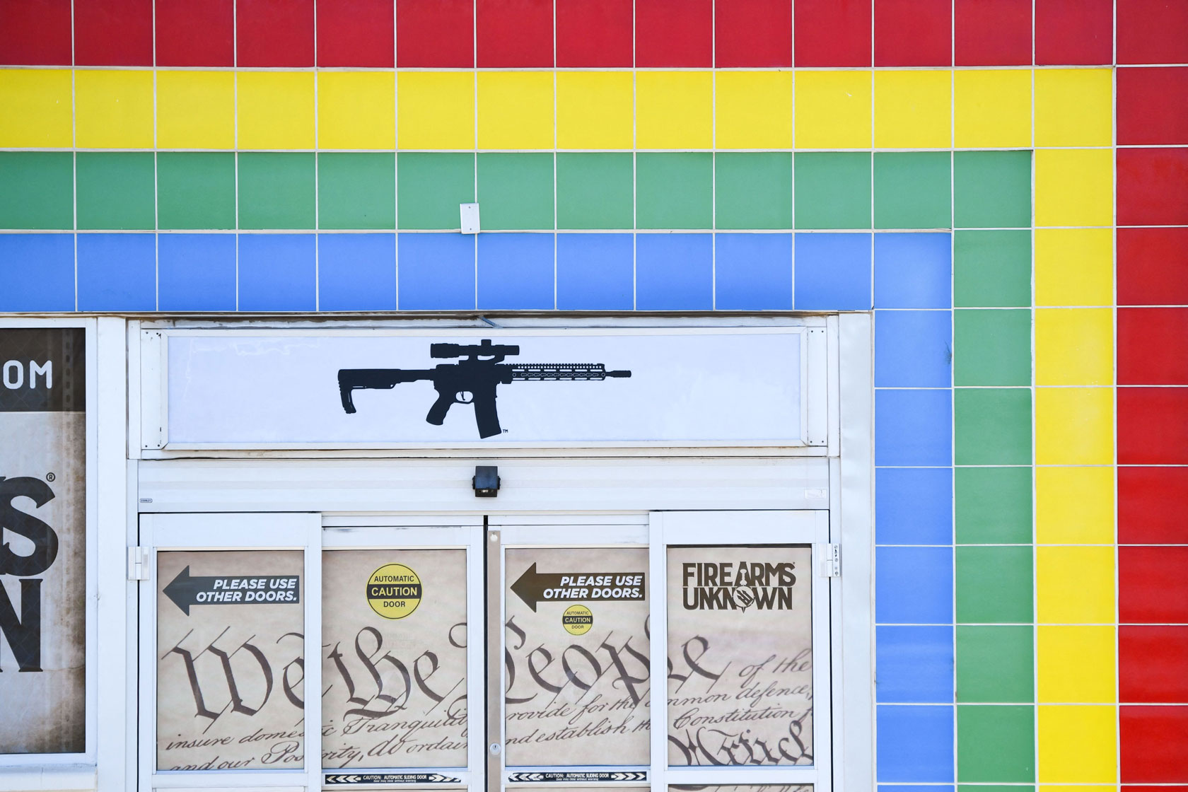 An AR-15-style rifle is displayed on signage for an Arizona gun store.