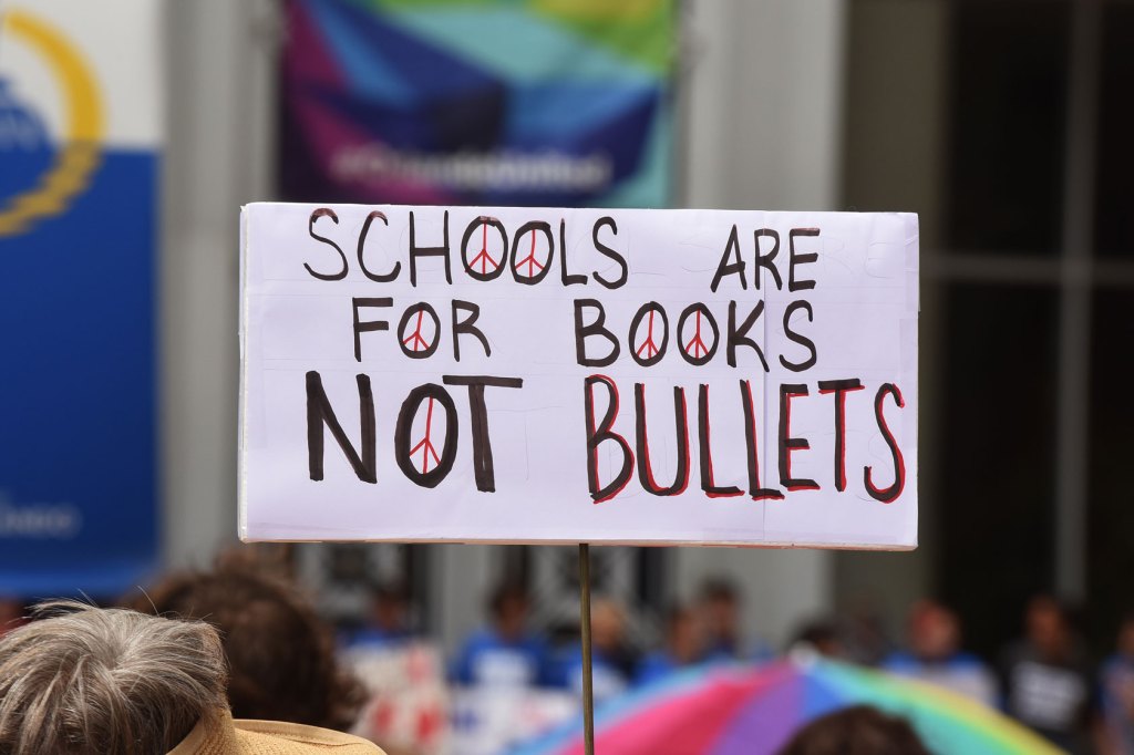 Photo shows gun safety advocates at a march holding a sign that reads 