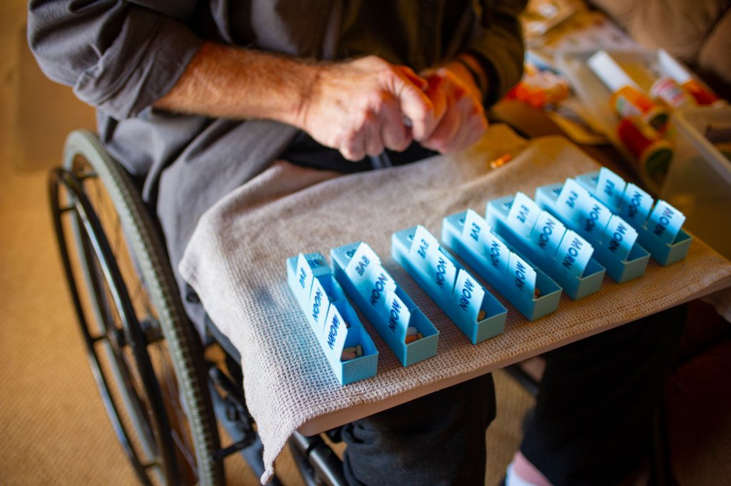 Image showing a disabled person hand-sorting prescription pills