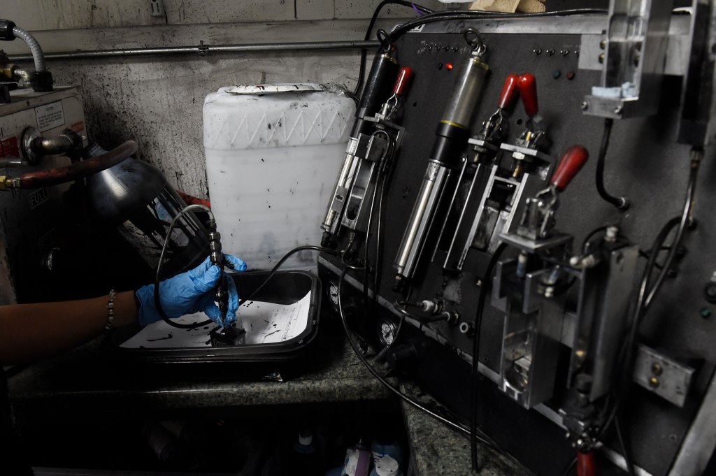 A machine filling a black ink cartridge