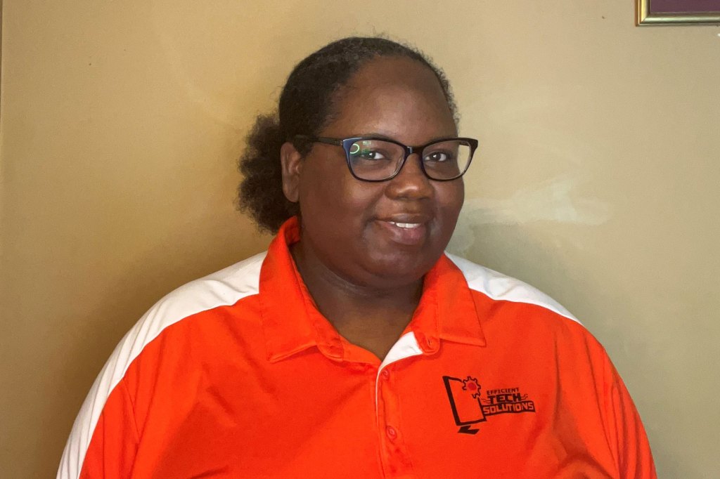 Photo shows Regina Monds smiling at the camera wearing an orange shirt.