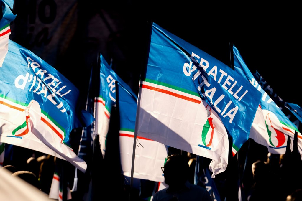 Supporters hold flags for Giorgia Meloni's Brothers of Italy party during a campaign event in Rome.
