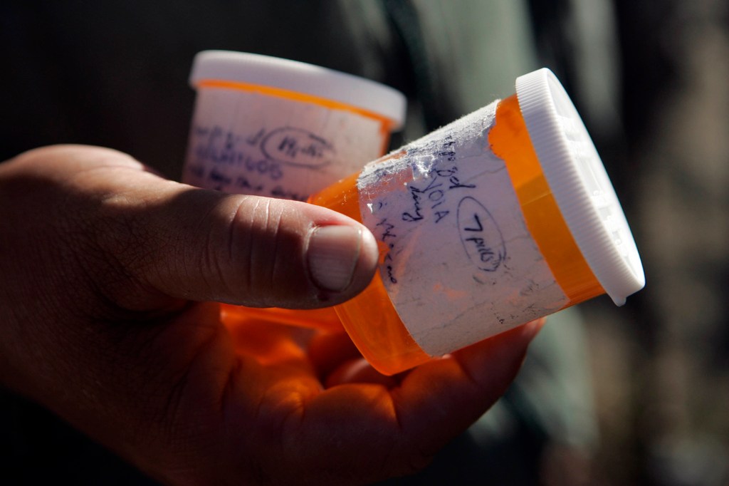 Close-up on hand holding pill bottles