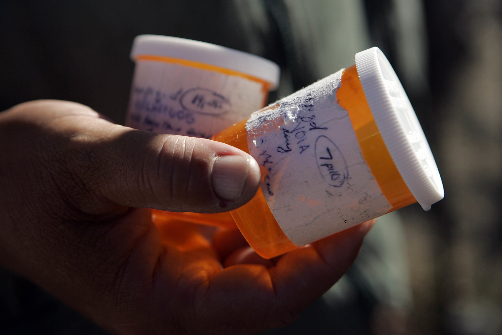 Close-up on hand holding pill bottles