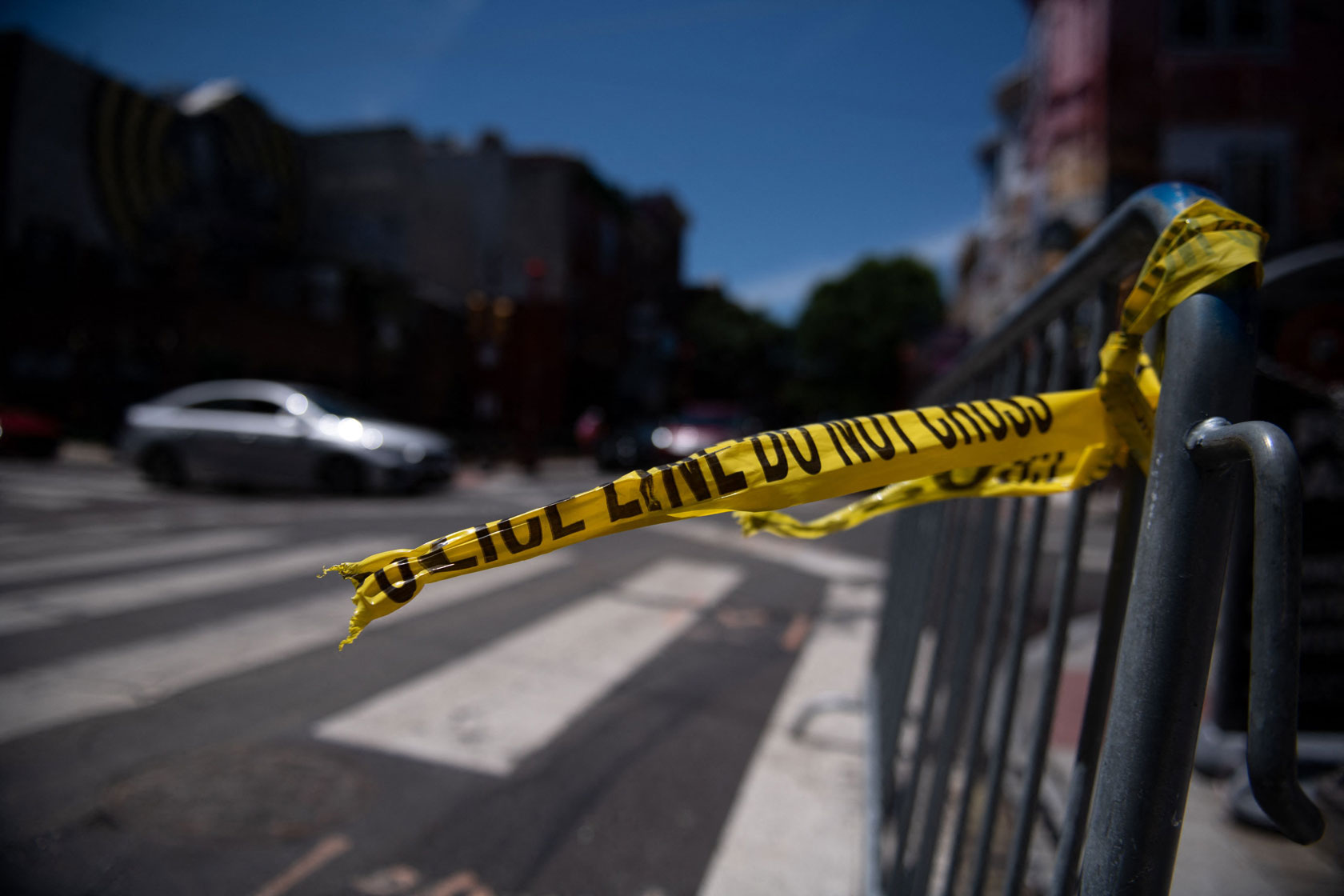 Police tape hangs from a barricade at the corner of 3rd and South Street in Philadelphia.