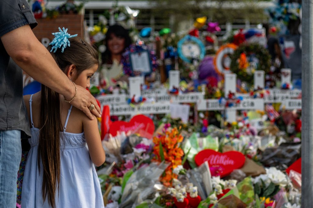 A father and his daughter pay their respects to those lost during the mass shooting at Robb Elementary School.