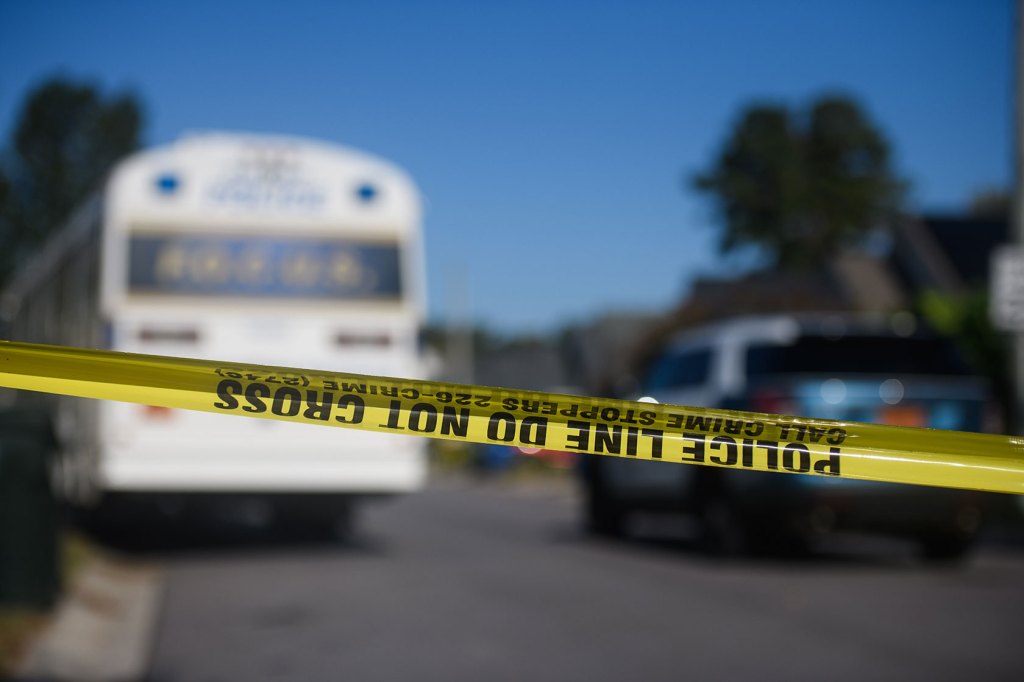 Photo shows crime scene tape stretching across a neighborhood street.