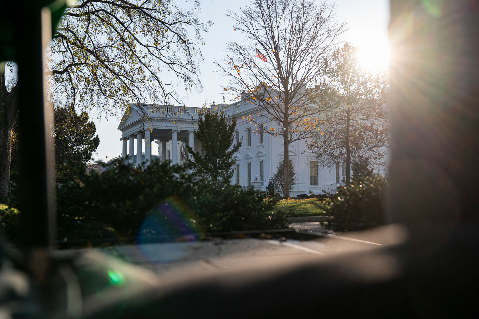 The sun is rising behind the White House.