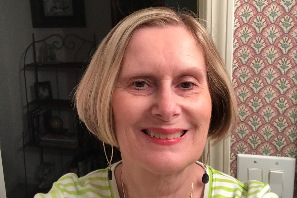 Photo shows Cheryle Johnson taking a selfie wearing a green and white shirt.