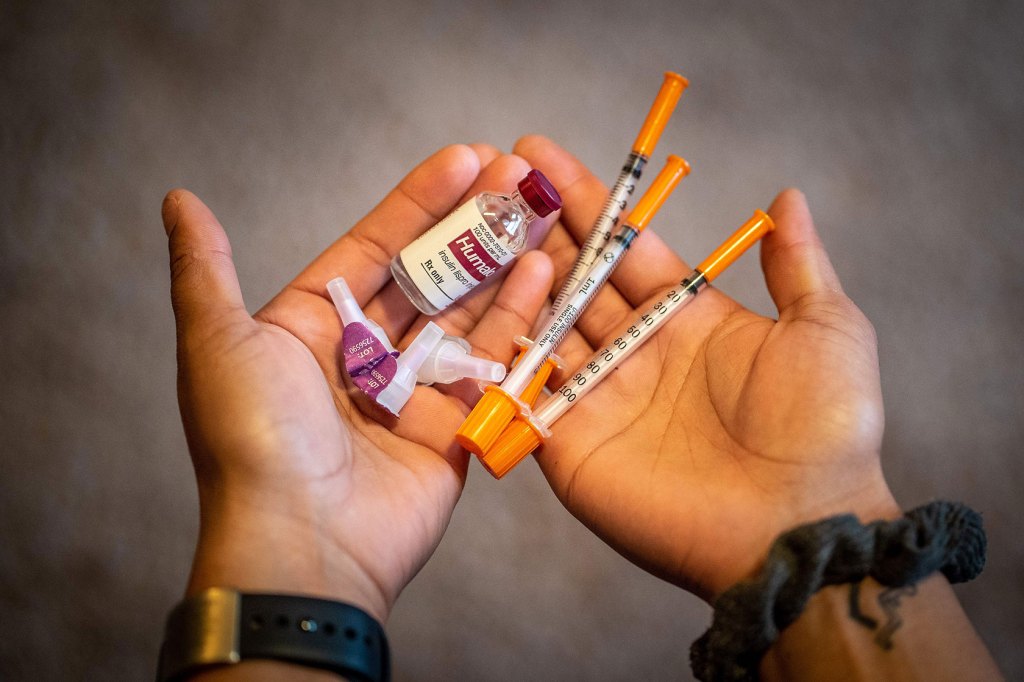 A woman shows her insulin kit.