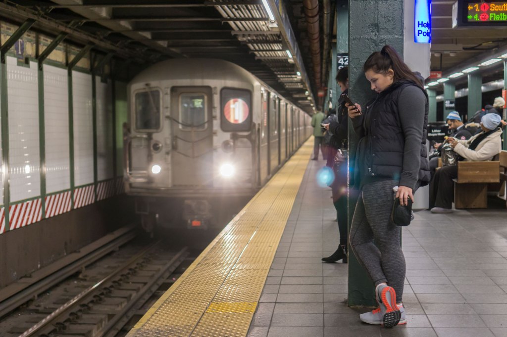 Subway riders check their phones as a train arrives in New York City on January 8, 2016. (Getty/Richard B. Levine)