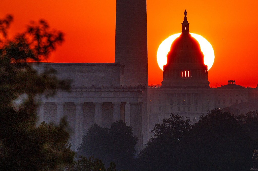 The sun rises behind the U.S. Capitol Dome